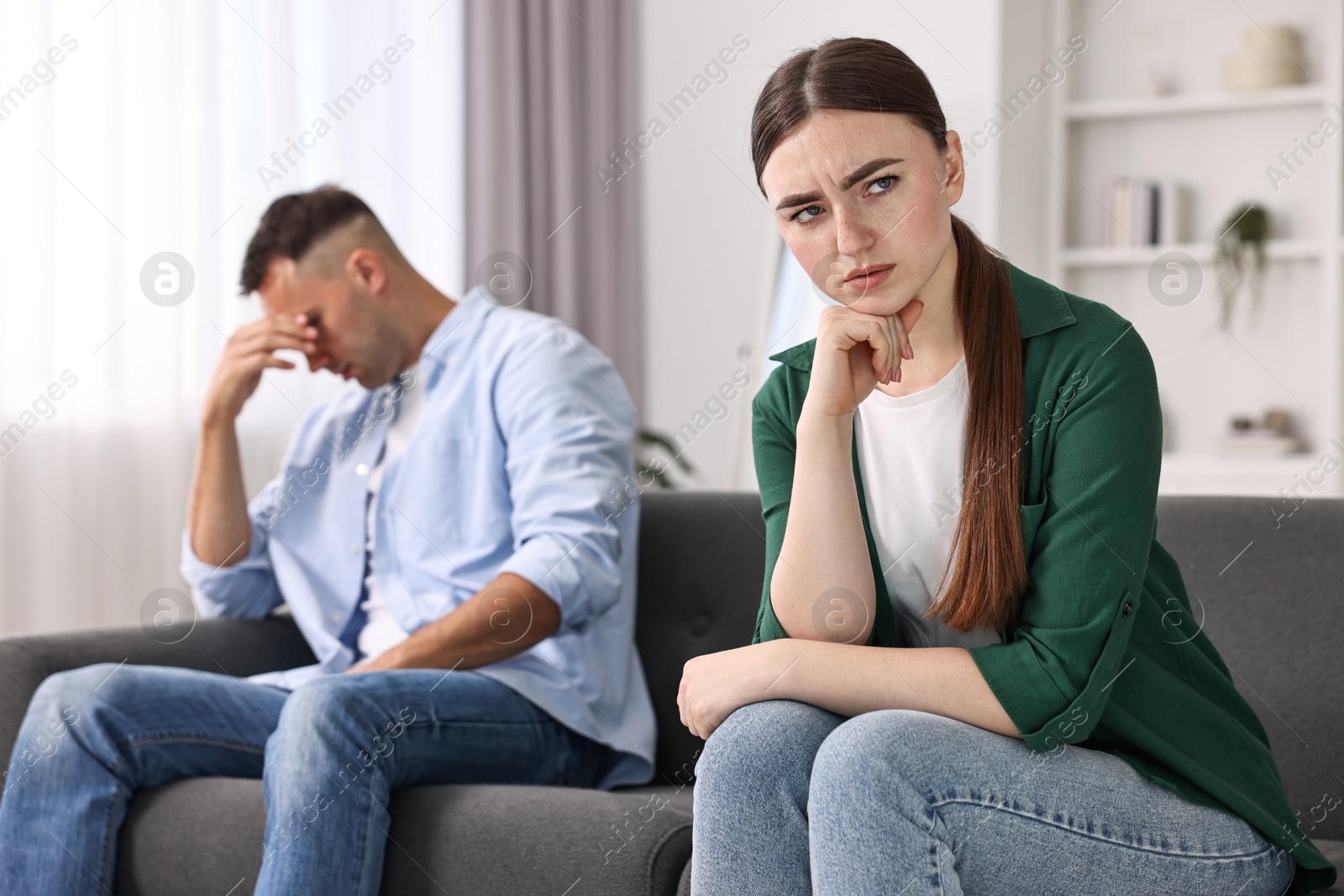 Photo of Upset woman ignoring her husband at home, selective focus