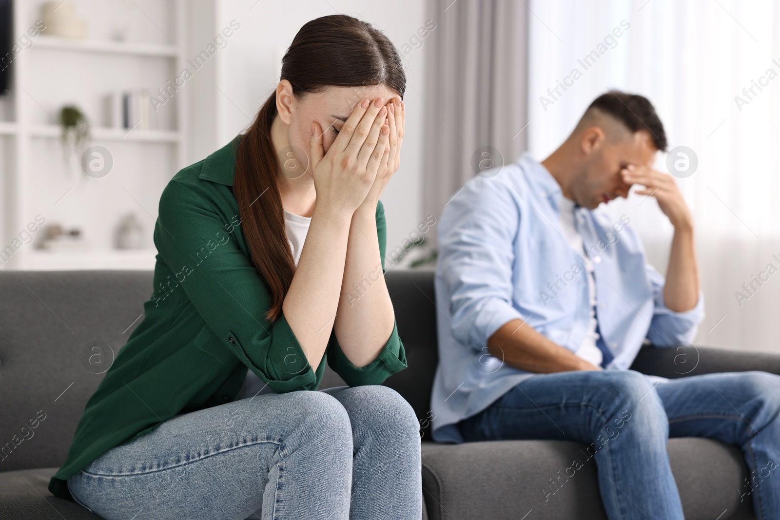 Photo of Upset woman ignoring her husband at home, selective focus