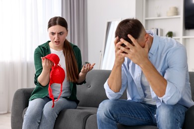 Photo of Puzzled wife finding mistress bra and unfaithful husband at home