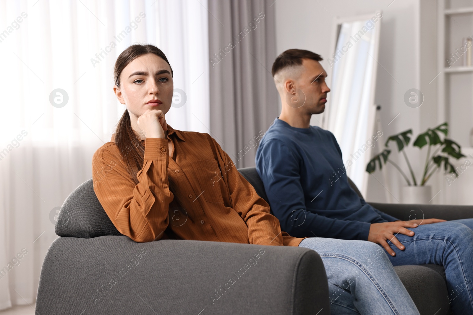 Photo of Offended couple ignoring each other at home