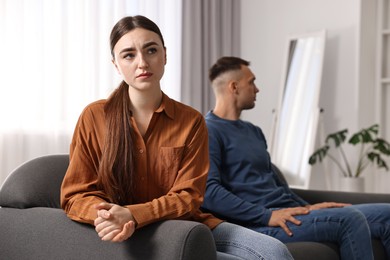 Photo of Offended couple ignoring each other at home, selective focus