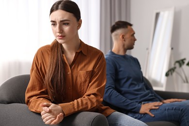 Photo of Offended couple ignoring each other at home, selective focus