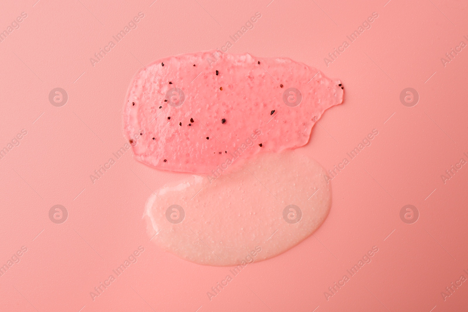 Photo of Smears of body scrubs on light pink background, top view