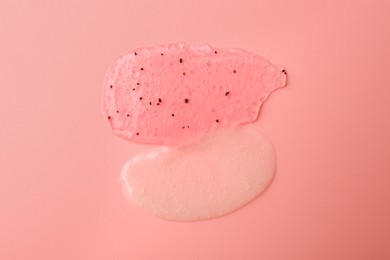 Photo of Smears of body scrubs on light pink background, top view