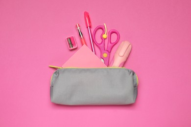 Photo of Pencil case and different stationery on pink background, flat lay