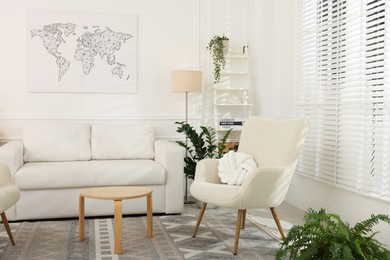 Photo of Soft armchairs, coffee table, sofa and green houseplants in living room