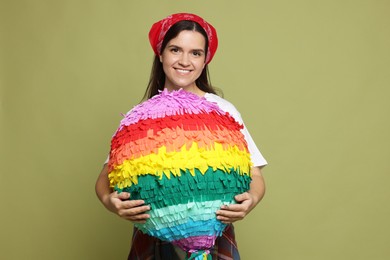 Photo of Happy woman with colorful pinata on green background