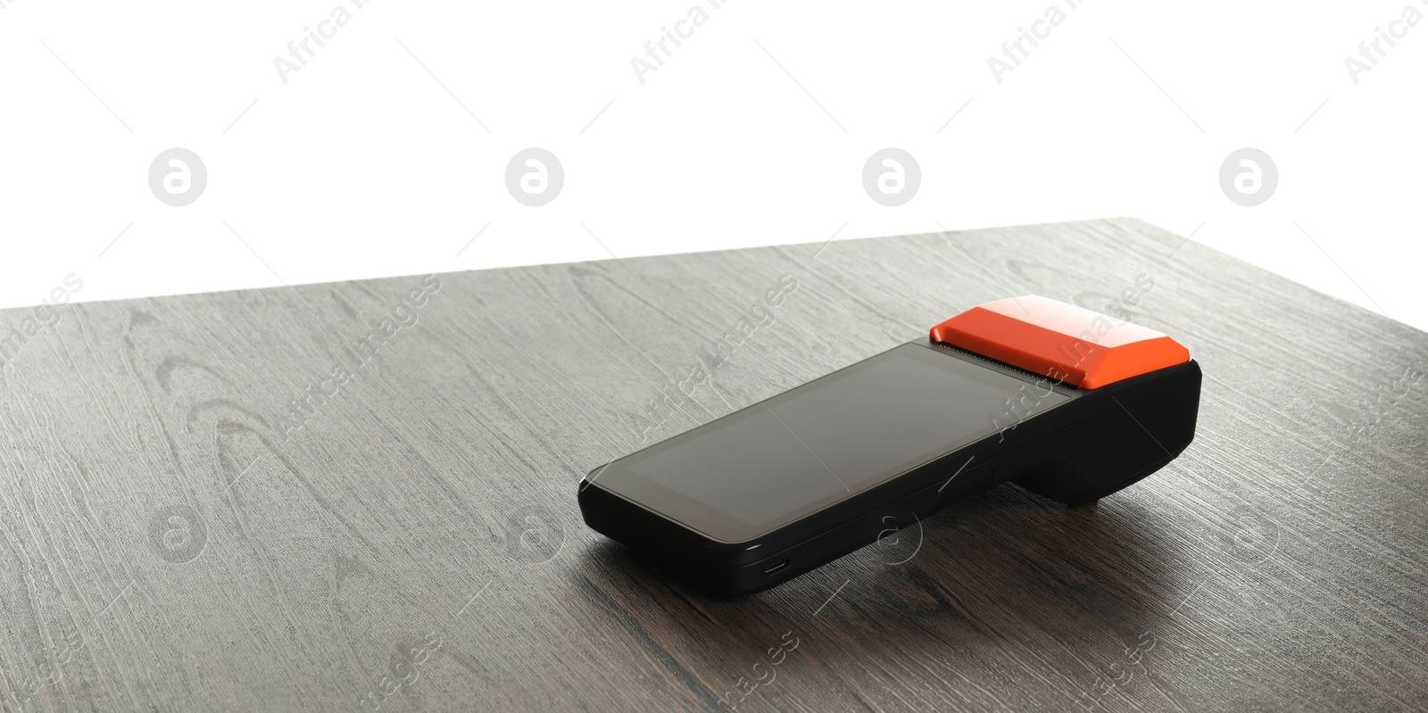 Photo of Payment terminal on wooden table against white background