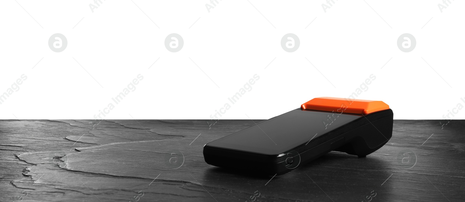 Photo of Payment terminal on black table against white background