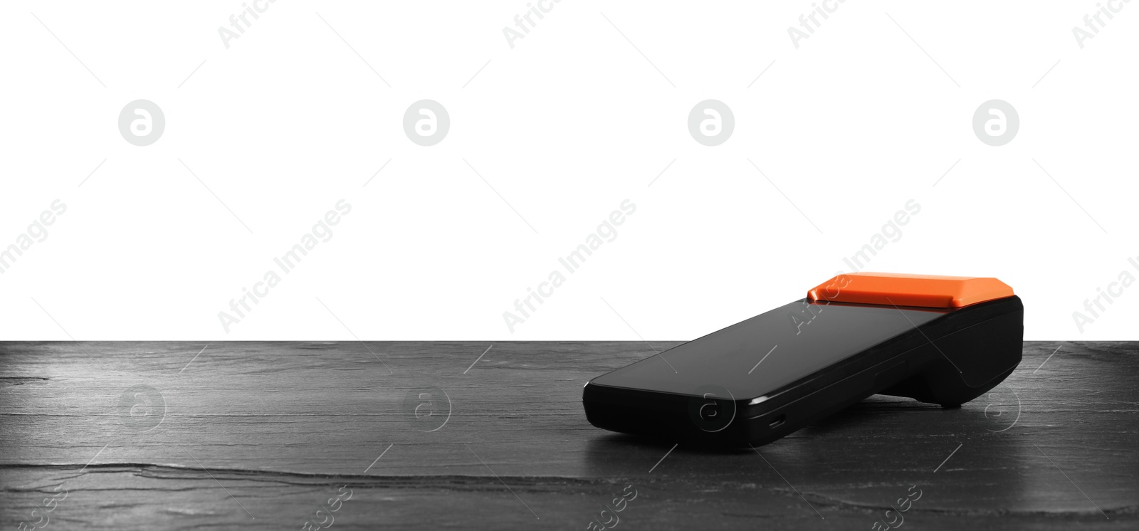 Photo of Payment terminal on black table against white background