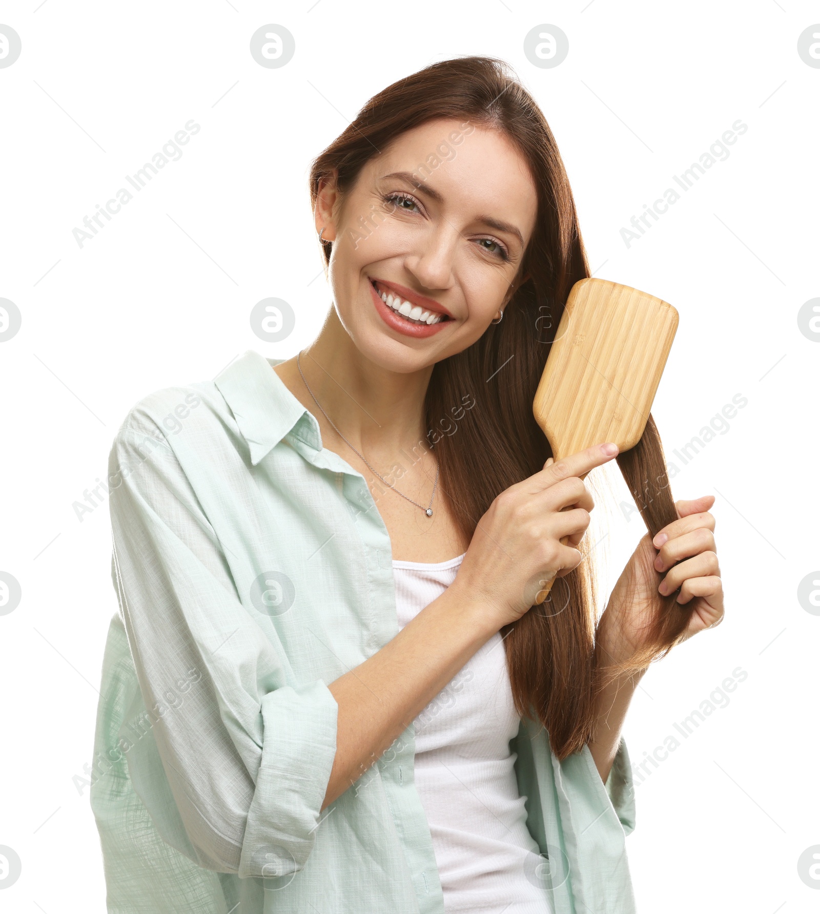 Photo of Smiling woman brushing her hair on white background