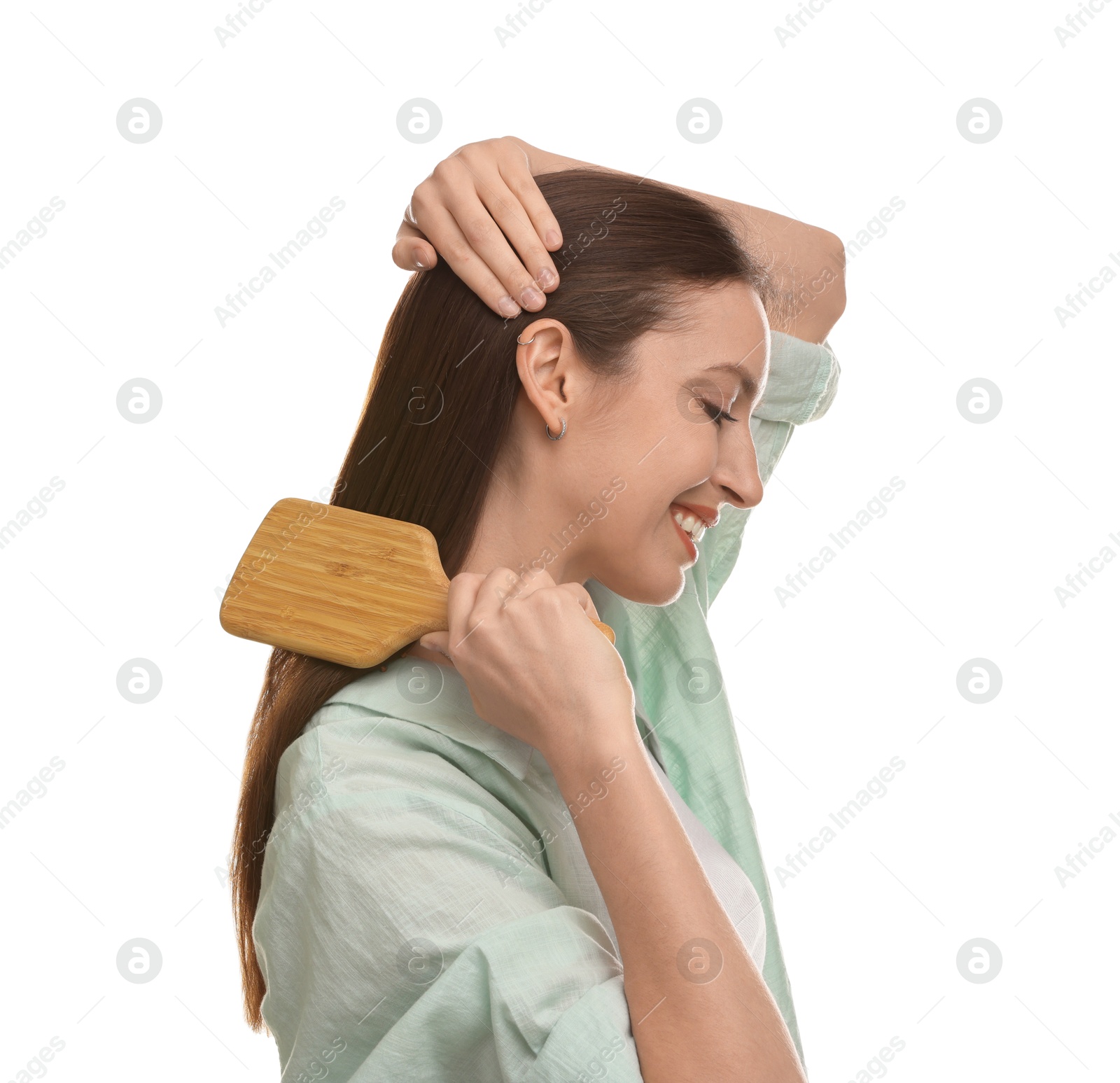 Photo of Smiling woman brushing her hair on white background