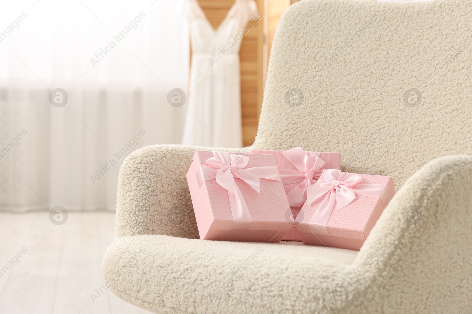 Photo of Gift boxes for wedding day in armchair indoors, space for text