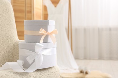 Photo of Gift boxes for wedding day in armchair indoors, space for text