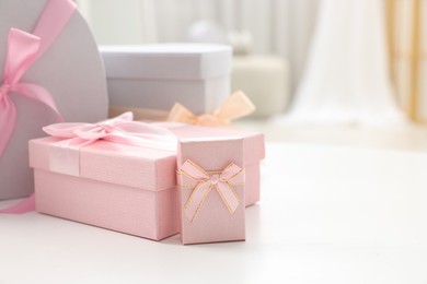 Photo of Gift boxes for wedding day on white table indoors, closeup. Space for text