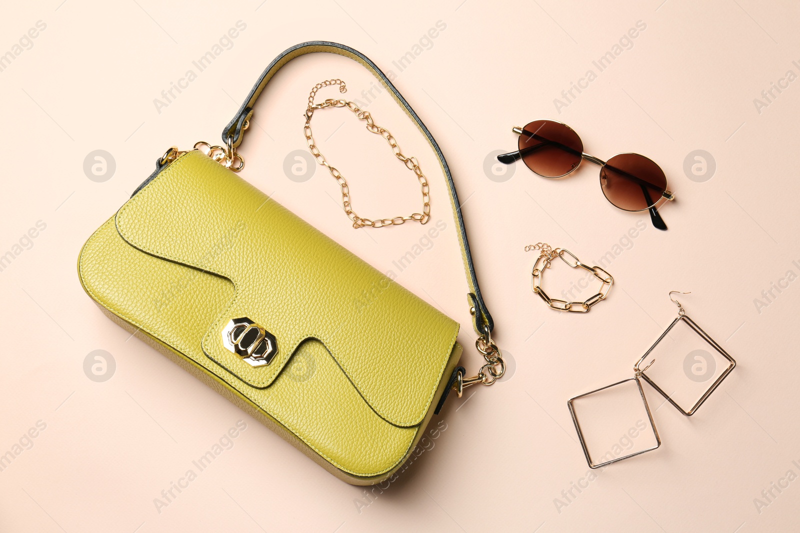 Photo of Beautiful bag and stylish accessories on beige background, flat lay