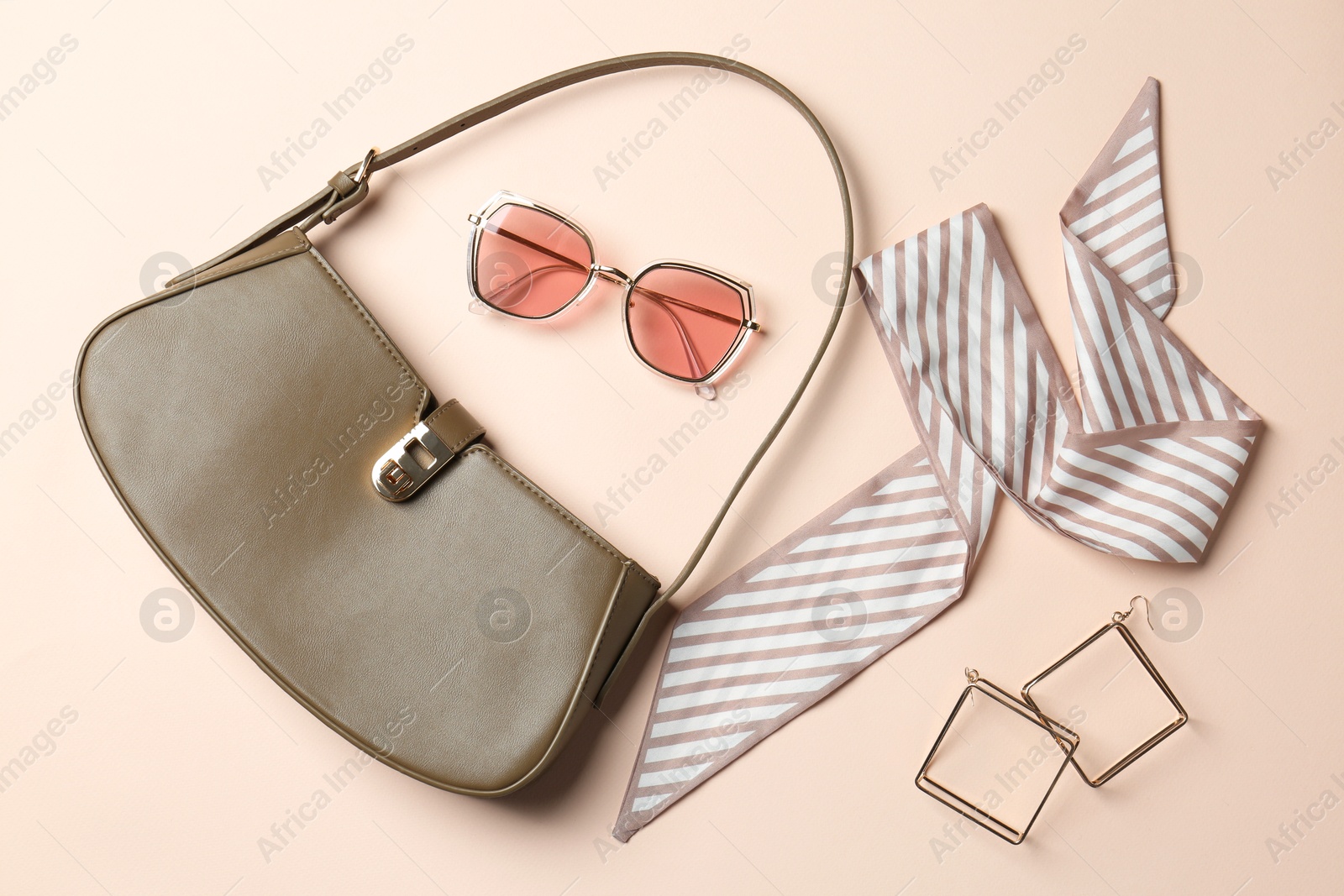 Photo of Beautiful bag and stylish accessories on beige background, flat lay