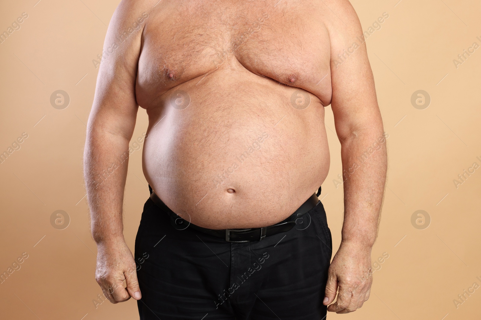 Photo of Man with excessive belly fat on beige background, closeup. Overweight problem