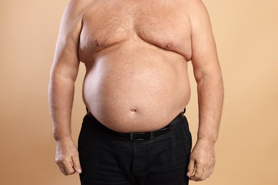 Photo of Man with excessive belly fat on beige background, closeup. Overweight problem