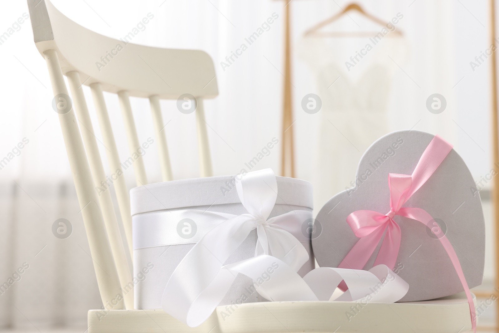 Photo of Gift boxes for wedding day on chair indoors