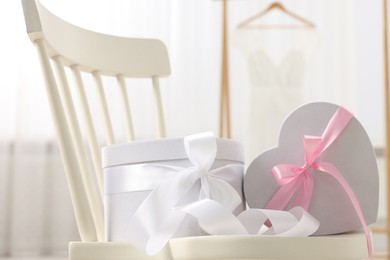 Photo of Gift boxes for wedding day on chair indoors