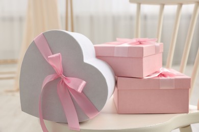 Photo of Gift boxes for wedding day on chair indoors, closeup