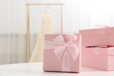 Photo of Gift boxes for wedding day on white table indoors, space for text