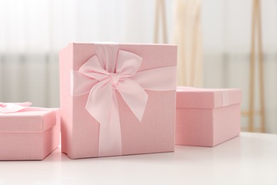 Photo of Gift boxes for wedding day on white table indoors, closeup