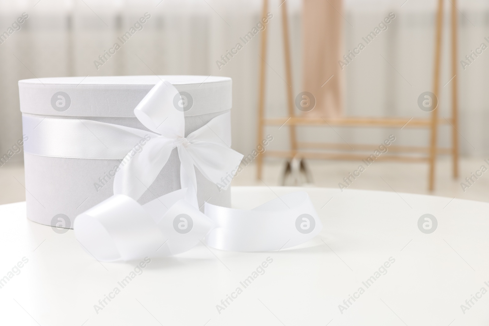 Photo of Gift box for wedding day on white table indoors, space for text