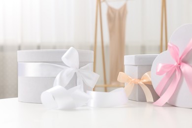 Photo of Different gift boxes on white table indoors