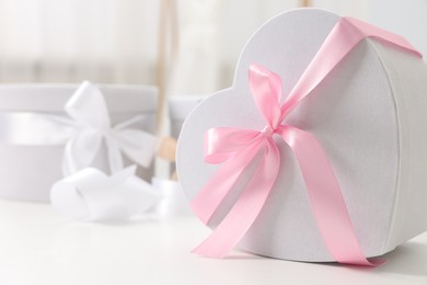 Photo of Gift boxes for wedding day on white table indoors, closeup. Space for text