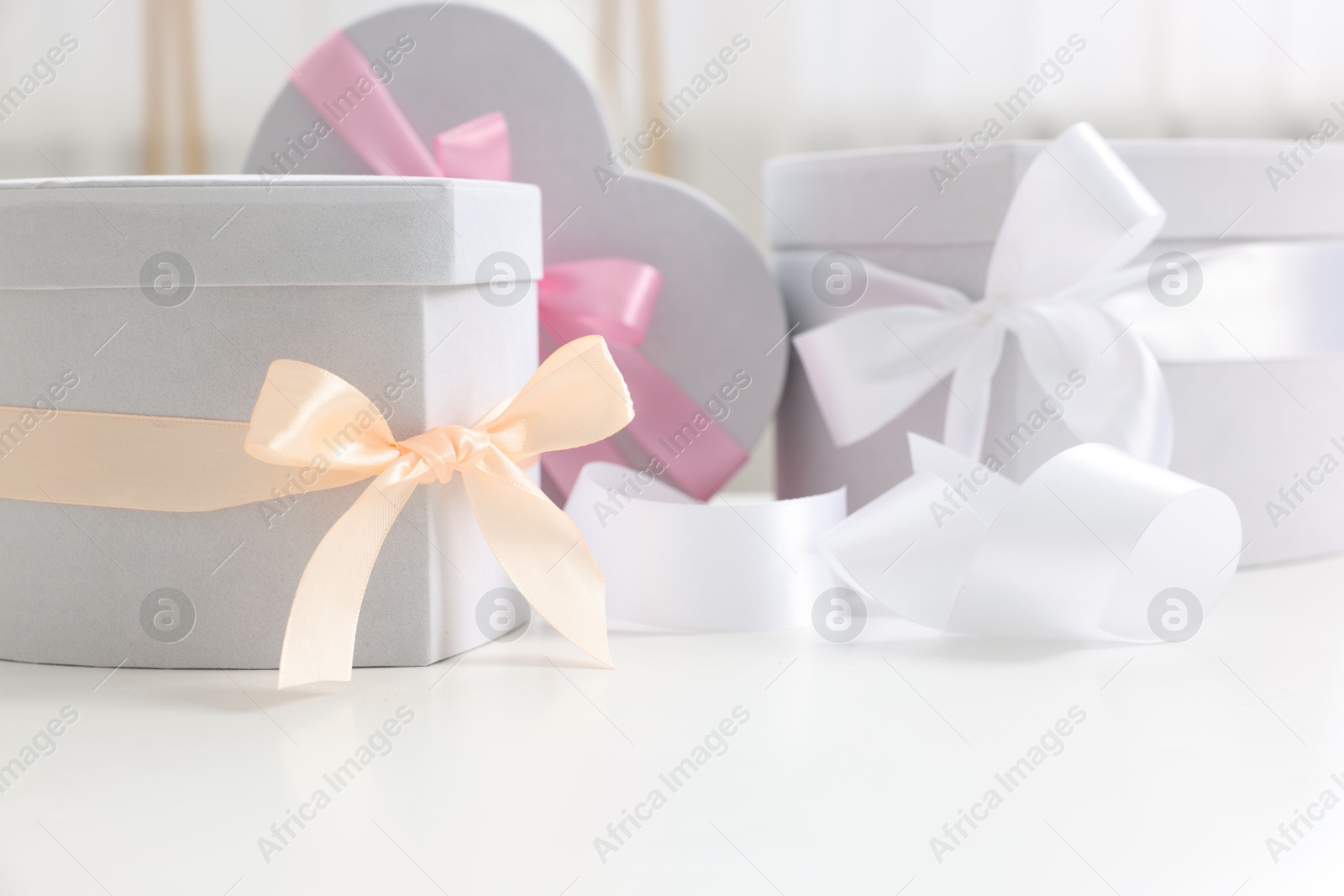 Photo of Gift boxes for wedding day on white table indoors, closeup