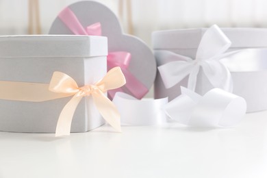 Photo of Gift boxes for wedding day on white table indoors, closeup