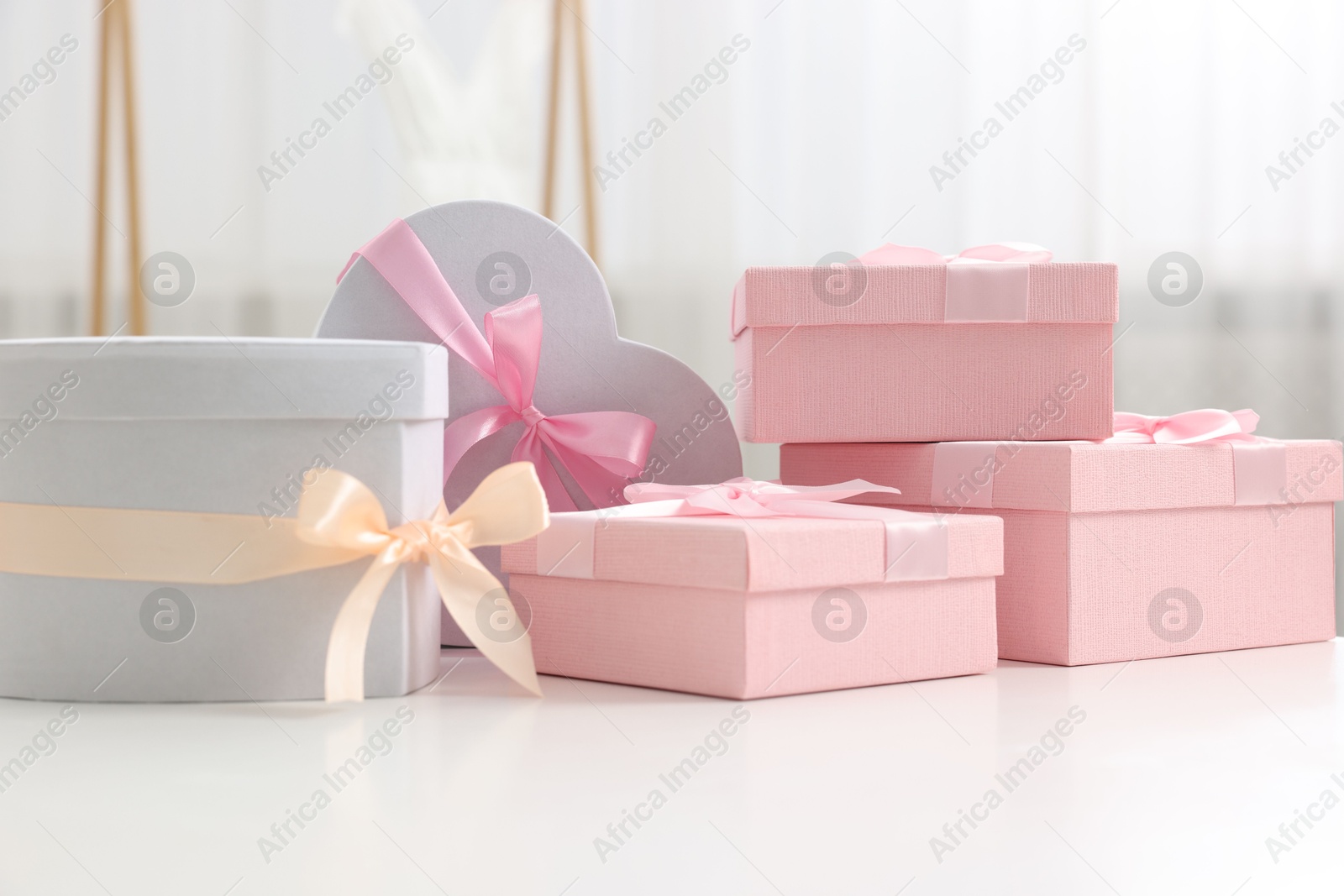 Photo of Different gift boxes on white table indoors