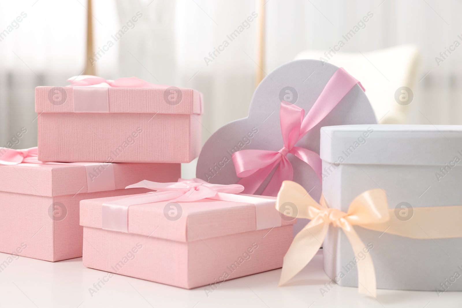 Photo of Gift boxes for wedding day on white table indoors, closeup