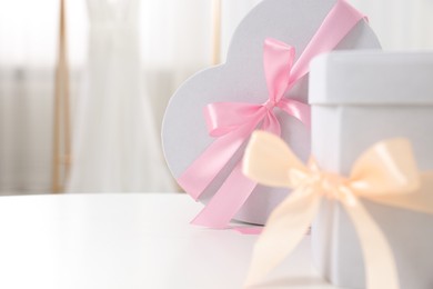 Photo of Gift boxes for wedding day on white table indoors, closeup. Space for text