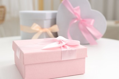 Photo of Gift boxes for wedding day on white table indoors, closeup