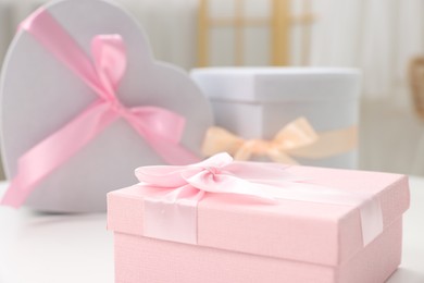 Photo of Gift boxes for wedding day on white table indoors, closeup