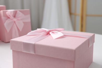 Photo of Gift boxes for wedding day on white table indoors, closeup