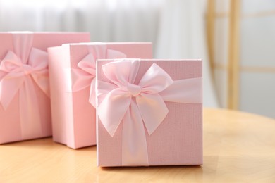 Photo of Gift boxes for wedding day on wooden table indoors, closeup