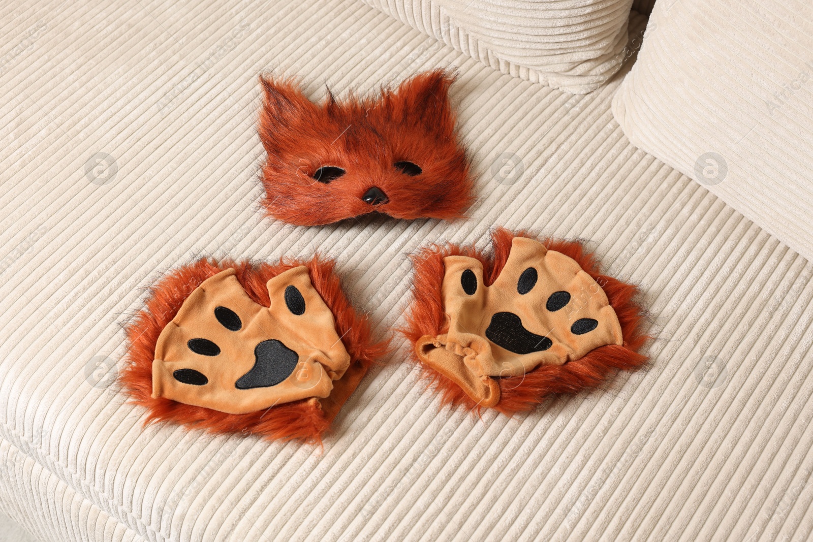 Photo of Quadrobics. Fox mask and gloves on sofa, above view