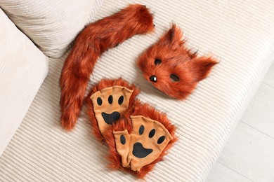 Photo of Quadrobics. Fox mask, gloves and tail on sofa, top view