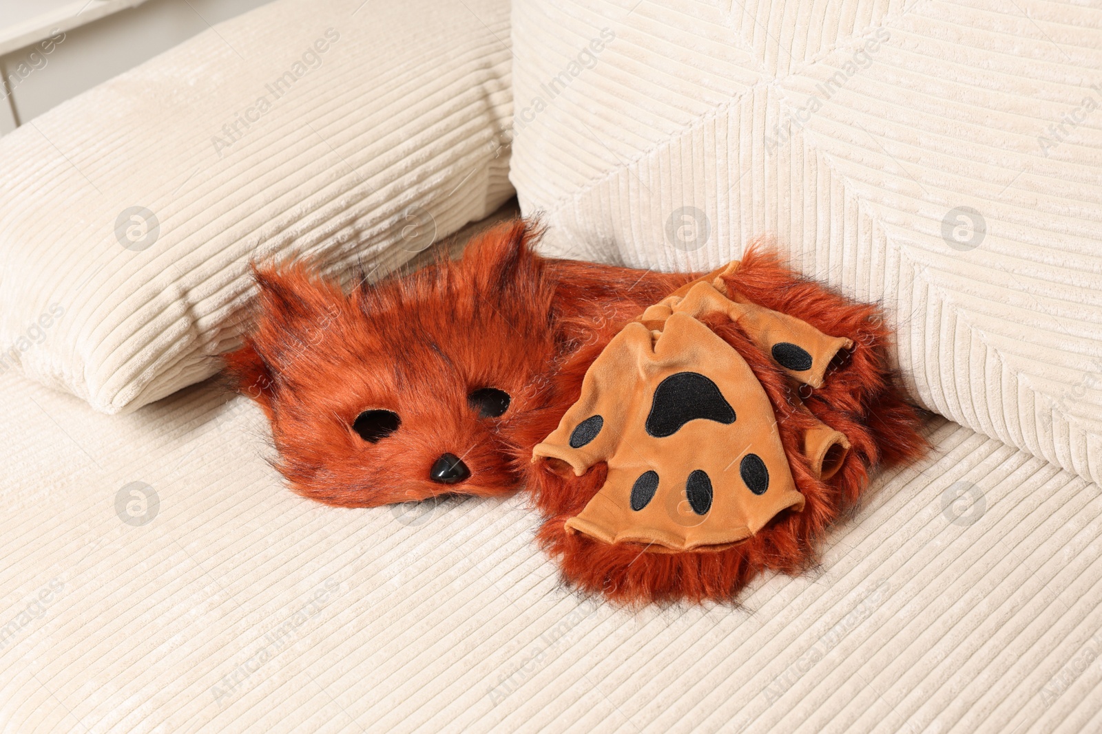 Photo of Quadrobics. Fox mask, gloves and tail on sofa indoors