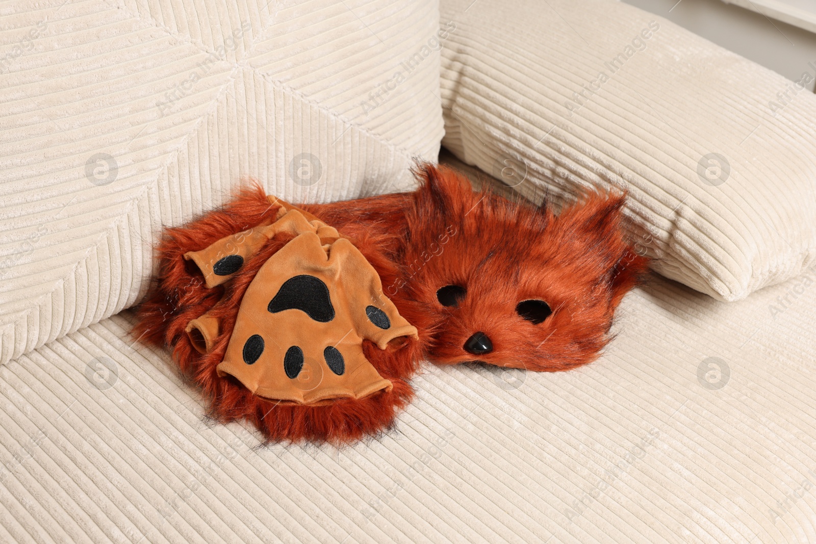 Photo of Quadrobics. Fox mask, gloves and tail on sofa indoors