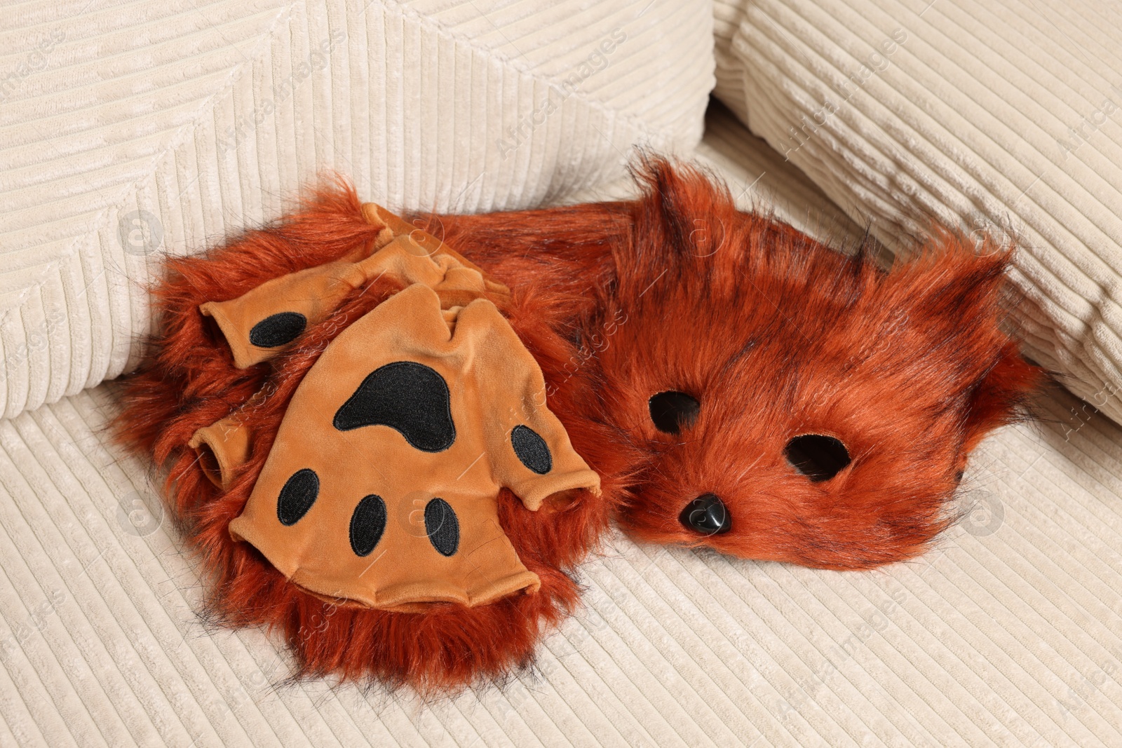 Photo of Quadrobics. Fox mask, gloves and tail on sofa indoors