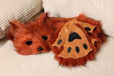 Photo of Quadrobics. Fox mask, gloves and tail on sofa indoors