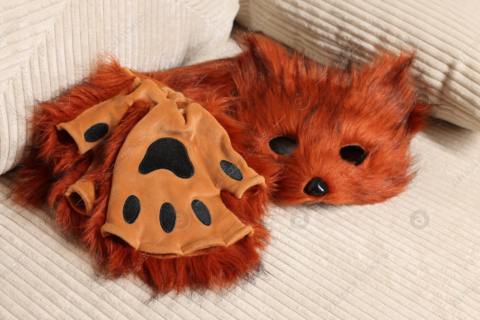 Photo of Quadrobics. Fox mask, gloves and tail on sofa indoors