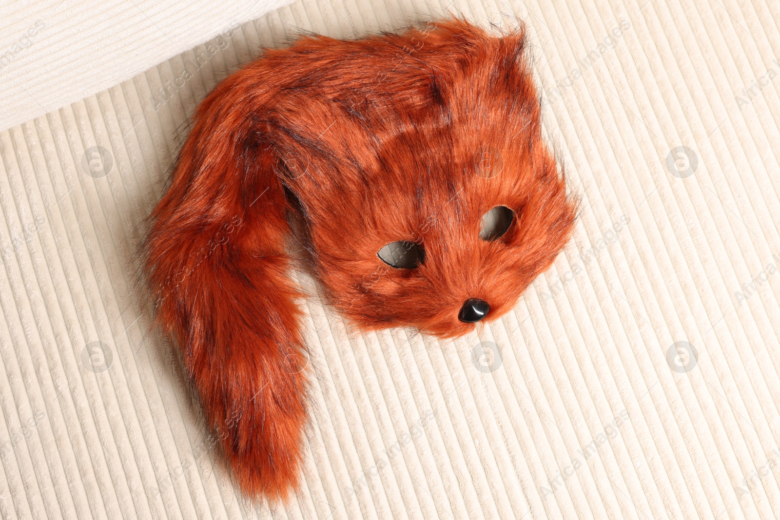 Photo of Quadrobics. Fox mask and tail on sofa, top view