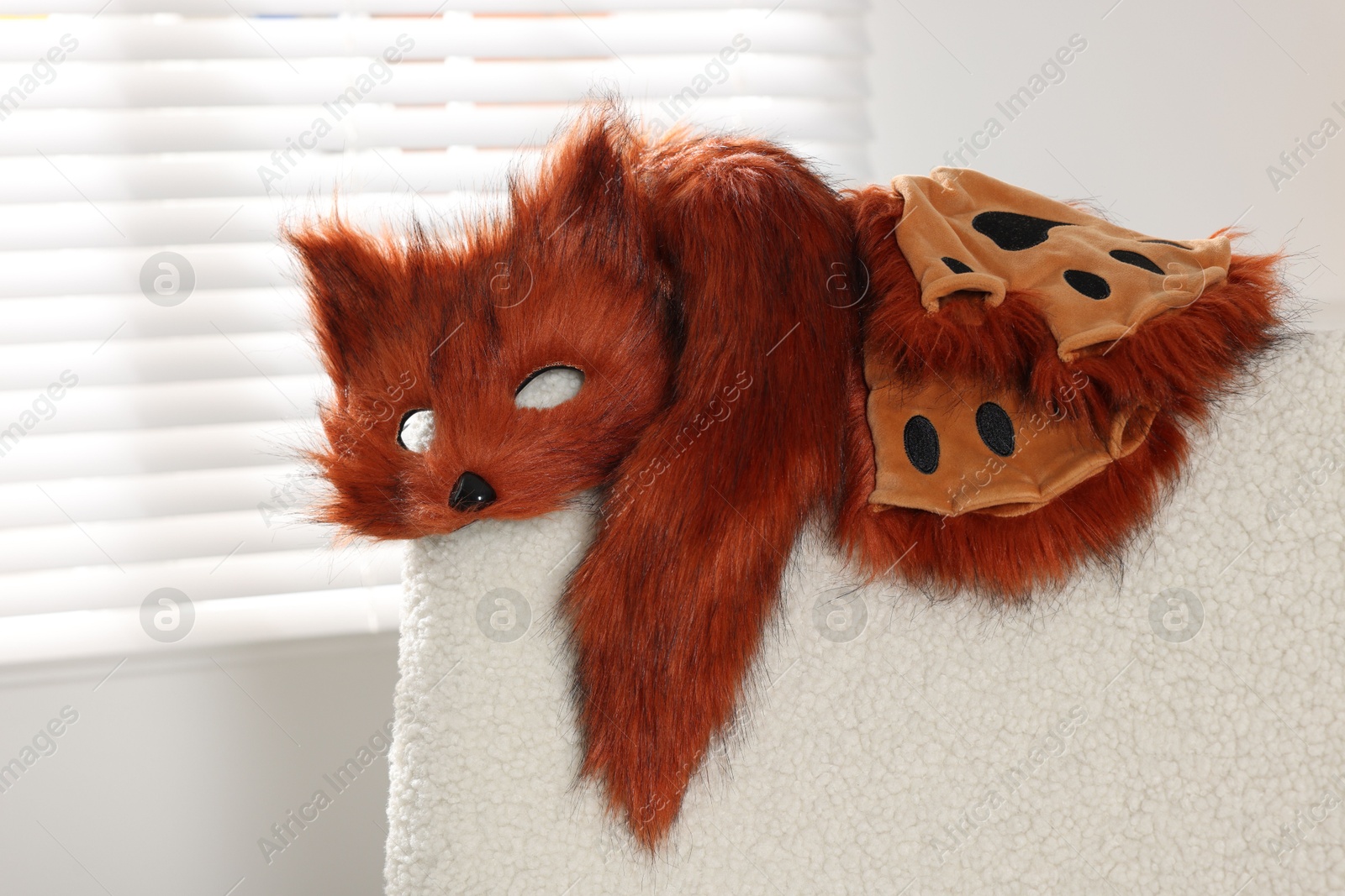 Photo of Quadrobics. Fox mask, gloves and tail on armchair indoors