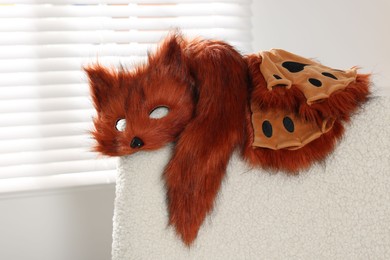 Photo of Quadrobics. Fox mask, gloves and tail on armchair indoors